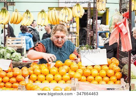 Subotica, Serbia - April 4, 2015: Senior Woman Selling Bananas And Oranges On Subotica Green Market 
