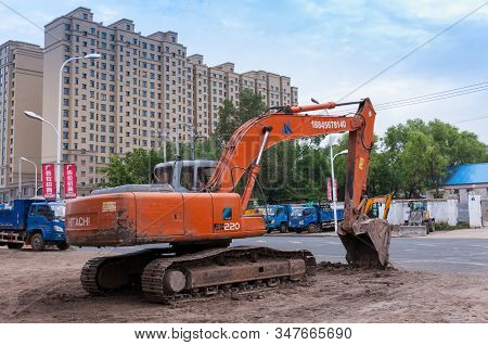 China, Heihe, July 2019: Excavator In A Residential Area, Streets Of The Chinese City Of Heihe In Th
