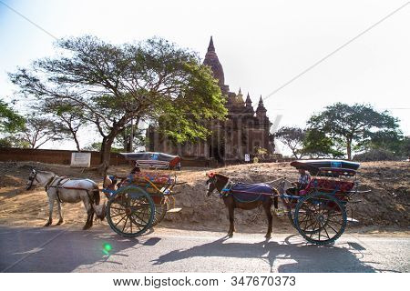 BAGAN, MYANMAR-MARCH 9, 2017: Tourists use horse drawn carriage for travel around Naga Yon Hpaya in ancient Bagan, Myanmar.(Burma)