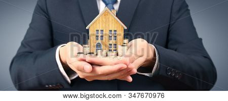 Growing Coins House On Stack Coins In Hand. Concept Of Investment Propert