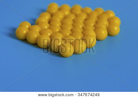 Yellow Vitamins On A Blue Background. Vitamin Complex Against The Virus. Multivitamins To Enhance He