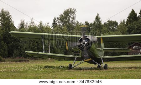 Agricultural Airplane Stands In A Field In The Green Grass.