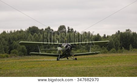 Agricultural Airplane Stands In A Field In The Green Grass.