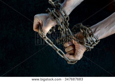 Hands Of A Slave Desperately Trying To Break The Iron Chain On A Dark Background, The Concept Of Pri