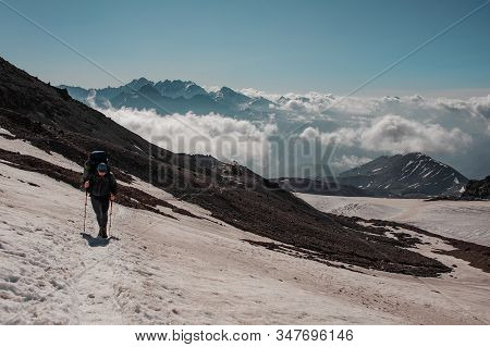 Man Walking On The Snowy Path Looking Down Climbing On The Mountain