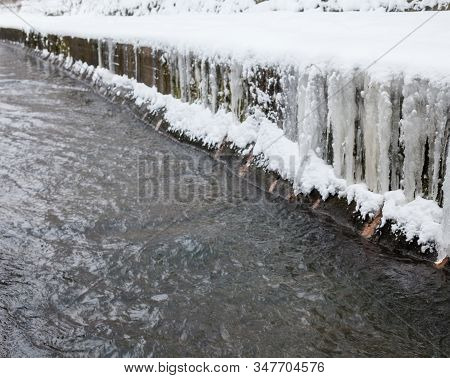 Urban Stream In Winter. Icicles On Concrete River Banks. The Lybid River (kyiv, Ukraine) In The Snow