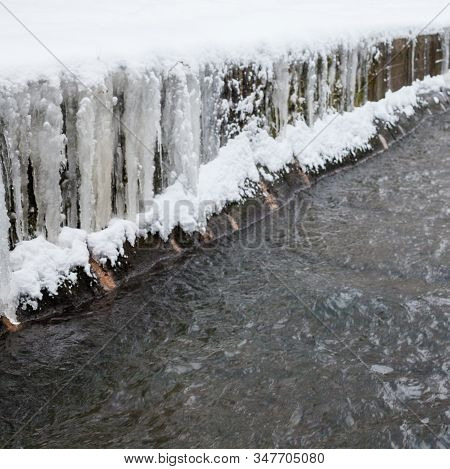 Urban Stream In Winter. Icicles On Concrete River Banks. The Lybid River (kyiv, Ukraine) In The Snow