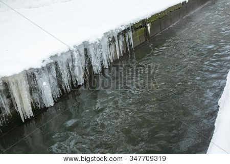 Urban Stream In Winter. Icicles On Concrete River Banks. The Lybid River (kyiv, Ukraine) In The Snow
