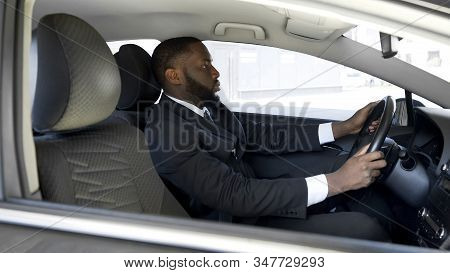 Busy Afro-american Man In Expensive Suit Driving To Business Meeting By Car