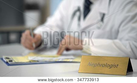 Professional Nephrologist Consulting Patient Online, Typing On Laptop In Clinic