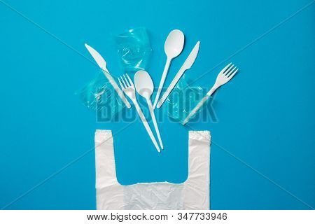 White Single-use Plastic Knives, Spoons, Forks And Bag On A Blue Background. Say No To Single Use Pl