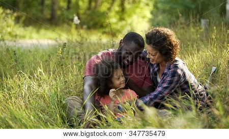Exemplary Couple Dedicate Their Free Time To Only Child, Relaxing In Summer Park