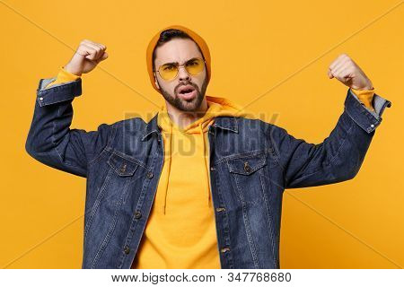 Perplexed Young Hipster Guy In Fashion Jeans Denim Clothes Posing Isolated On Yellow Orange Backgrou