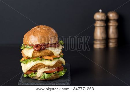 Homemade Chicken Burger With Fried Egg Tomato Lettuce Cucumber Dripping Mozzarella On Cutting Board 