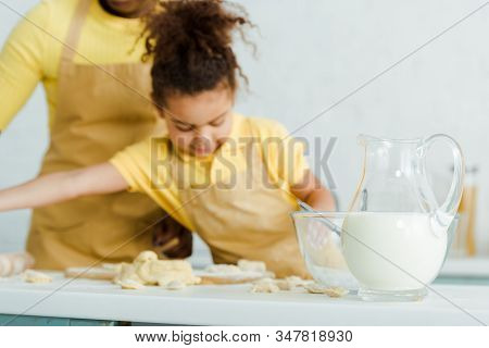 Selective Focus Of Jug With Milk Near Bowl And Cute African American Kid Sculping Dumplings Near Mot
