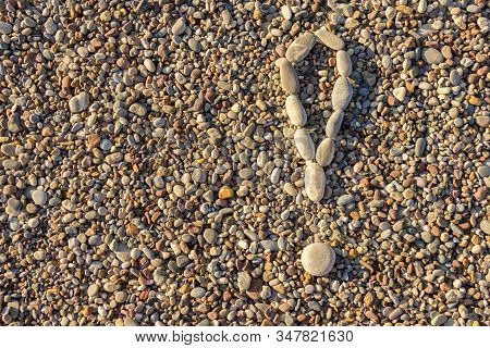 Exclamation Mark Laid Out With Stones On A Background Of Pebbles. Stones Background.