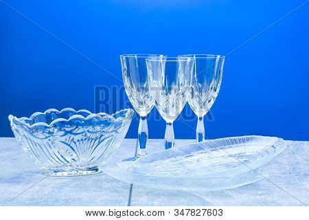 Three Crystal Glasses And Dishes With Close-up On A Blue Background