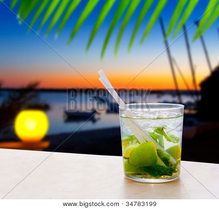 Cocktail Mojito in Balearic island sunset and palm trees [photo-illustration]