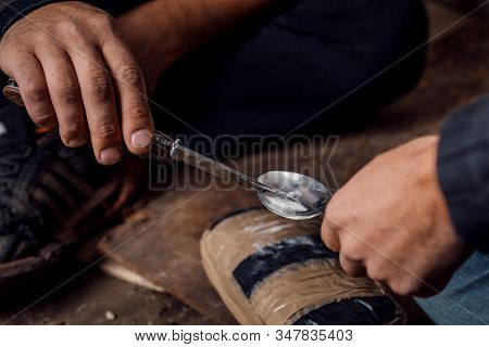Two Shabby  Men Preparing Drug Injection In Slums.