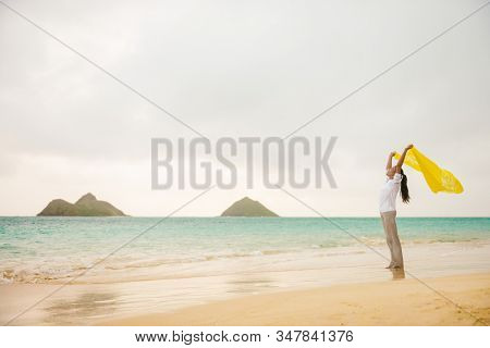 Beach vacation woman happy feeling free on Lanikai beach, Hawaii paradise honeymoon destination for USA summer travel holidays. Asian girl carefree with scarf in wind enjoying oceannature.