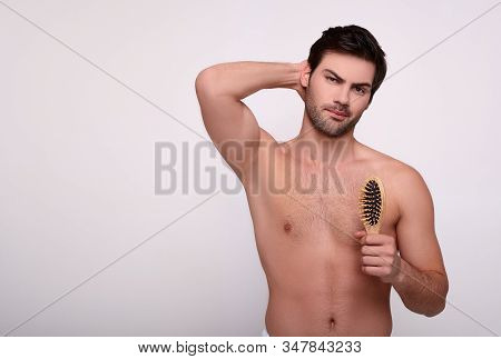 Charming Sexy Sports Young Man With Dark Hair Demonstrates His Smooth Armpit, In The Other Hand Hold