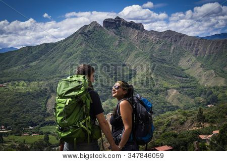 Backpacker Couple Holding Hands Surrounded By A Natural Landscape. Vilcabamba, Ecuador