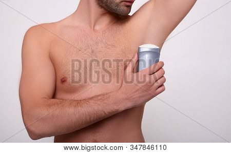 Cropped Frame, An Image Of A Sporty Muscular Male Body, A Man Uses Deodorant On The Armpit. The Conc