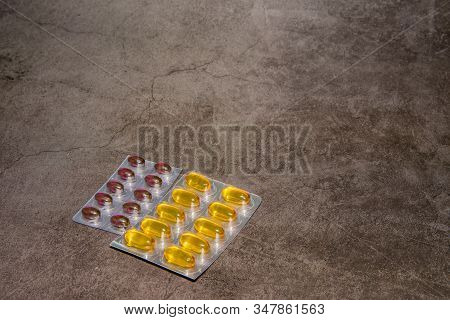 Two Foil Packages Of Gelcap Medicine Isolated On Black Background.
