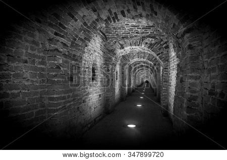 Brick tunnel archway made of red bricks as a passage between the two wings of a medieval castle. Granite stone an brick built Interior corridor way to bastions