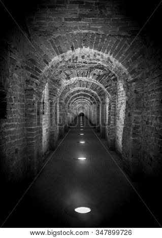 Brick tunnel archway made of red bricks as a passage between the two wings of a medieval castle. Granite stone an brick built Interior corridor way to bastions