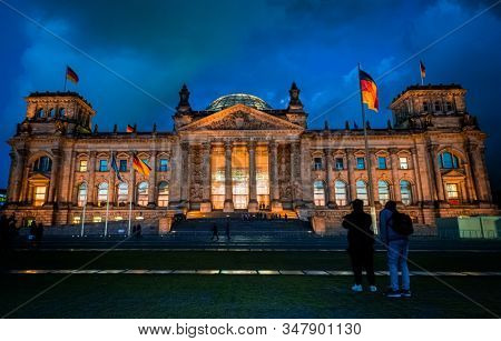 Famous Reichstag with german flags in evening