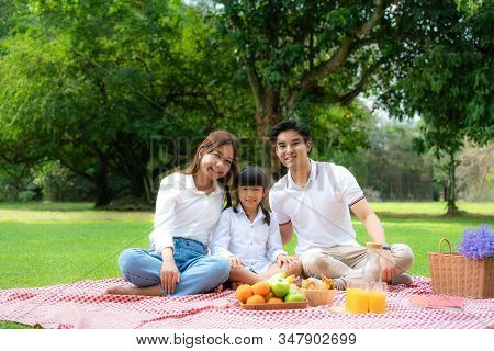 Asian Teen Family Happy Holiday Picnic Moment In The Park With Father, Mother And Daughter Looking A
