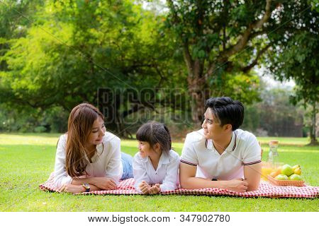 Asian Teen Family Happy Holiday Picnic Moment In The Park With Father, Mother And Daughter Lying On 