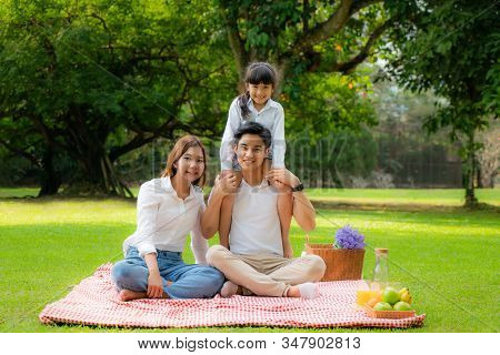 Asian Teen Family Happy Holiday Picnic Moment In The Park With Father, Mother And Daughter Looking A