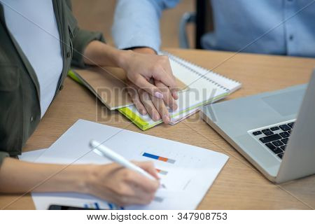 Close Up Picture Of Mans Han Tocuhing Womans Hand