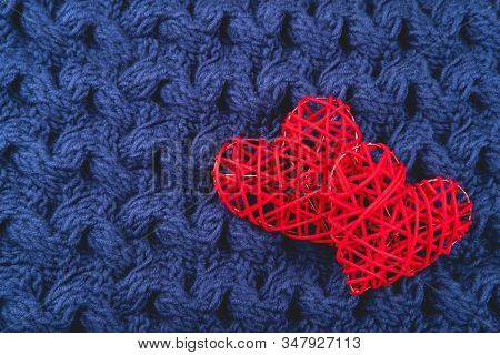 Two Beautiful Red Hearts On The Blue Knitted Background. St Valentines Concept With Copy Space.
