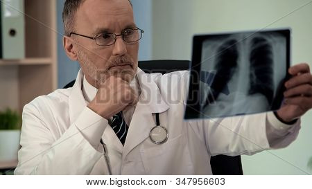 Male Pulmonologist Scrutinizing Chest X-ray, Looking For Pathology, Diagnostics