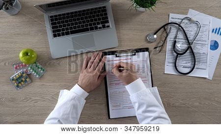 Top View Of General Practitioner Filling Health Insurance Claim Form, Healthcare
