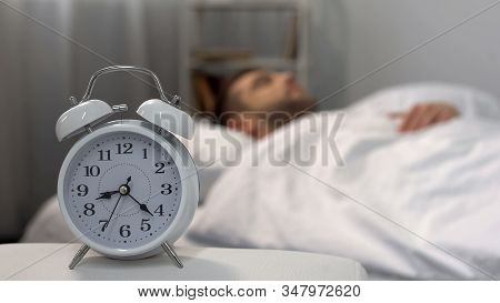Male Oversleeping In Morning, Alarm Ringing At Night Table, Time Management