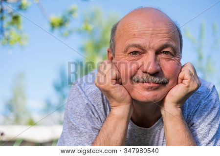 Elderly Spanish Man Resting, On Fresh Air Lying On Ground Smiling At Camera.