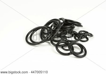 Hydraulic And Pneumatic O-rings In Black In Different Sizes On A White Background. Various Seals For
