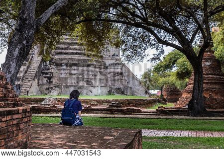 Aytthaya, Thailand, 22 Aug 2020 : Rear View Of Tourist Woman Is Sitting Alone Sit Rest At Wat Ratcha