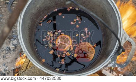Mulled Wine In A Tourist Pot Over Hot Camp Fire. Mulled Wine By The Fire. Mulled Wine Cooked On Fire