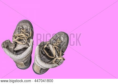 Travel Shoes, Old Shoes, Hiking Shoes On A Pink Background.