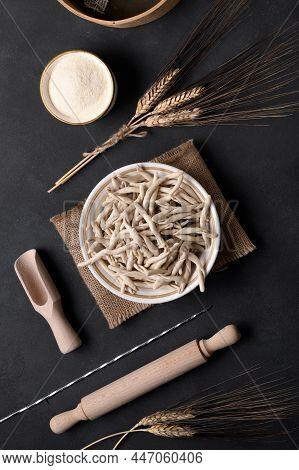 Whole Grain Wheat Raw Apulian Pasta Pizzarieddi Or Maccaruni In A Bowl On Black Table. Fresh Maccher