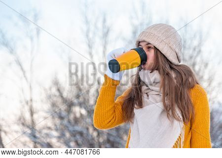 Portrait Of Young Woman In Yellow Sweater Drinking Coffee Outdoors
