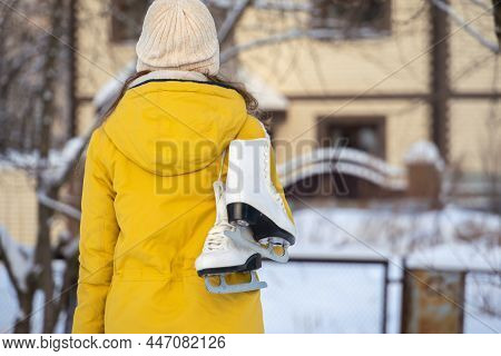 Young Woman In Yellow Jacket With Ice Skates Goes Home.
