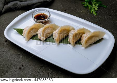 Chinese Gedza With Soy Sauce On Steam On Black Concrete Table