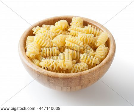 Uncooked Radiatori Pasta In Wooden Bowl Isolated On White Background With Clipping Path