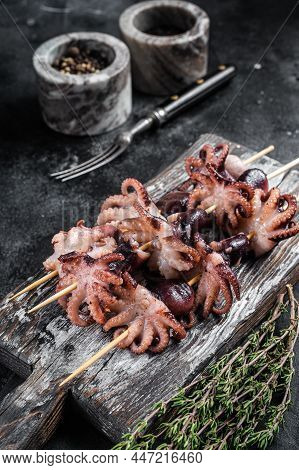 Skewers With Grilled Baby Mini Octopuses. Black Background. Top View